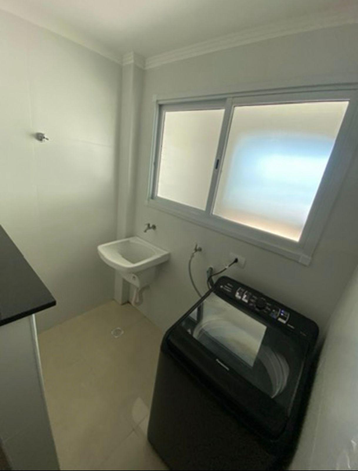 Área de serviço com tanque e máquina de lavar